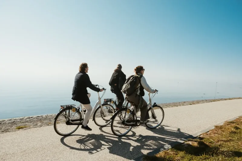 drie-mensen-fietsen-langs-de-kust-op-Vlieland-met-uitzicht-over-de-zee.