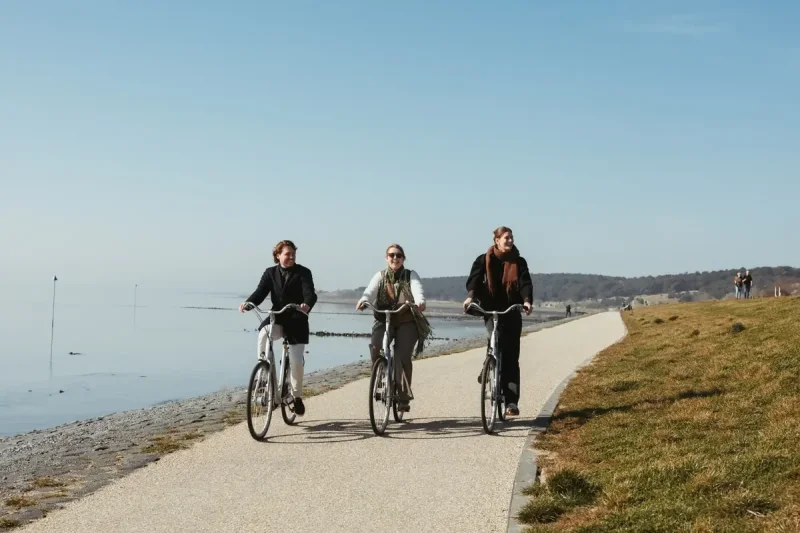drie-mensen-fietsen-langs-de-kust-op-Vlieland.