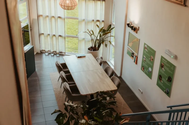 interieur-donia-huys-met-tafel-stoelen-en-informatiemuur-met-kaart-van-vlieland.